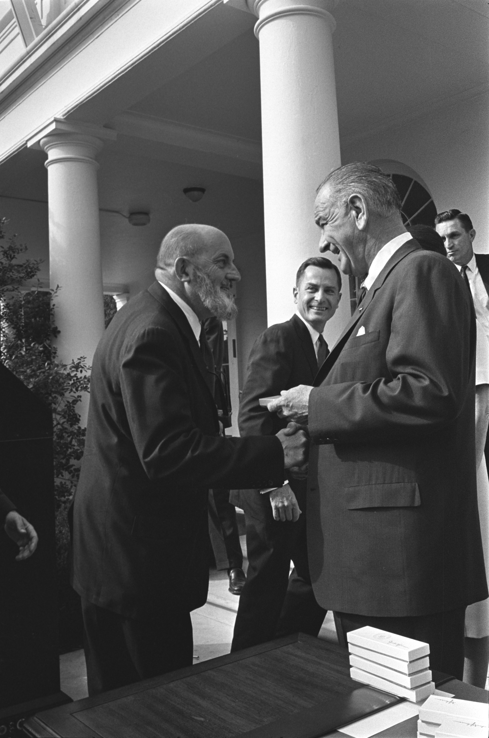 President Lyndon B. Johnson presents American photographer Ansel Adams with a bill signing pen.