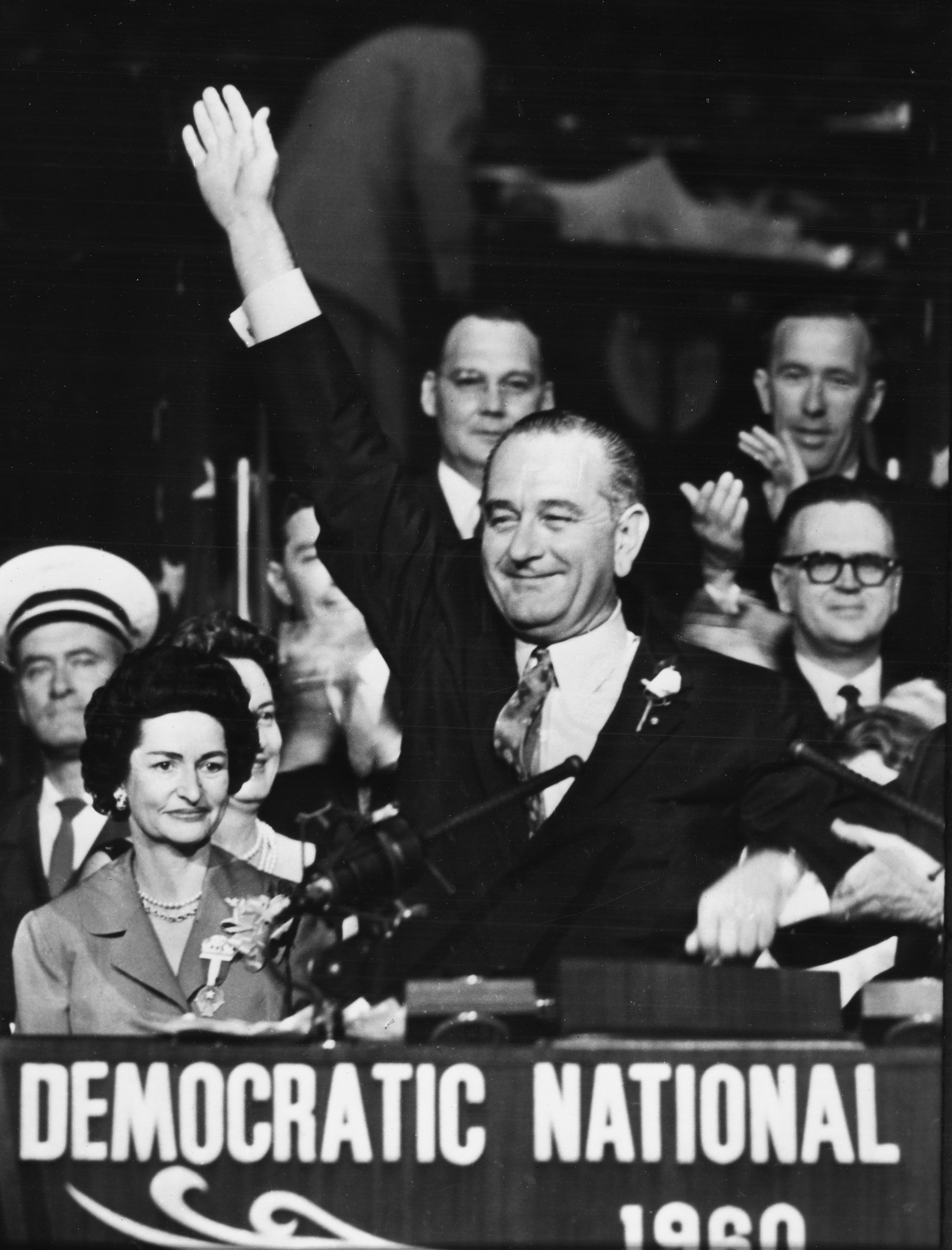 Senator Lyndon B. Johnson waves from the podium, with Lady Bird Johnson smiling by his side, at the Democratic National Convention in Los Angeles California in 1960.