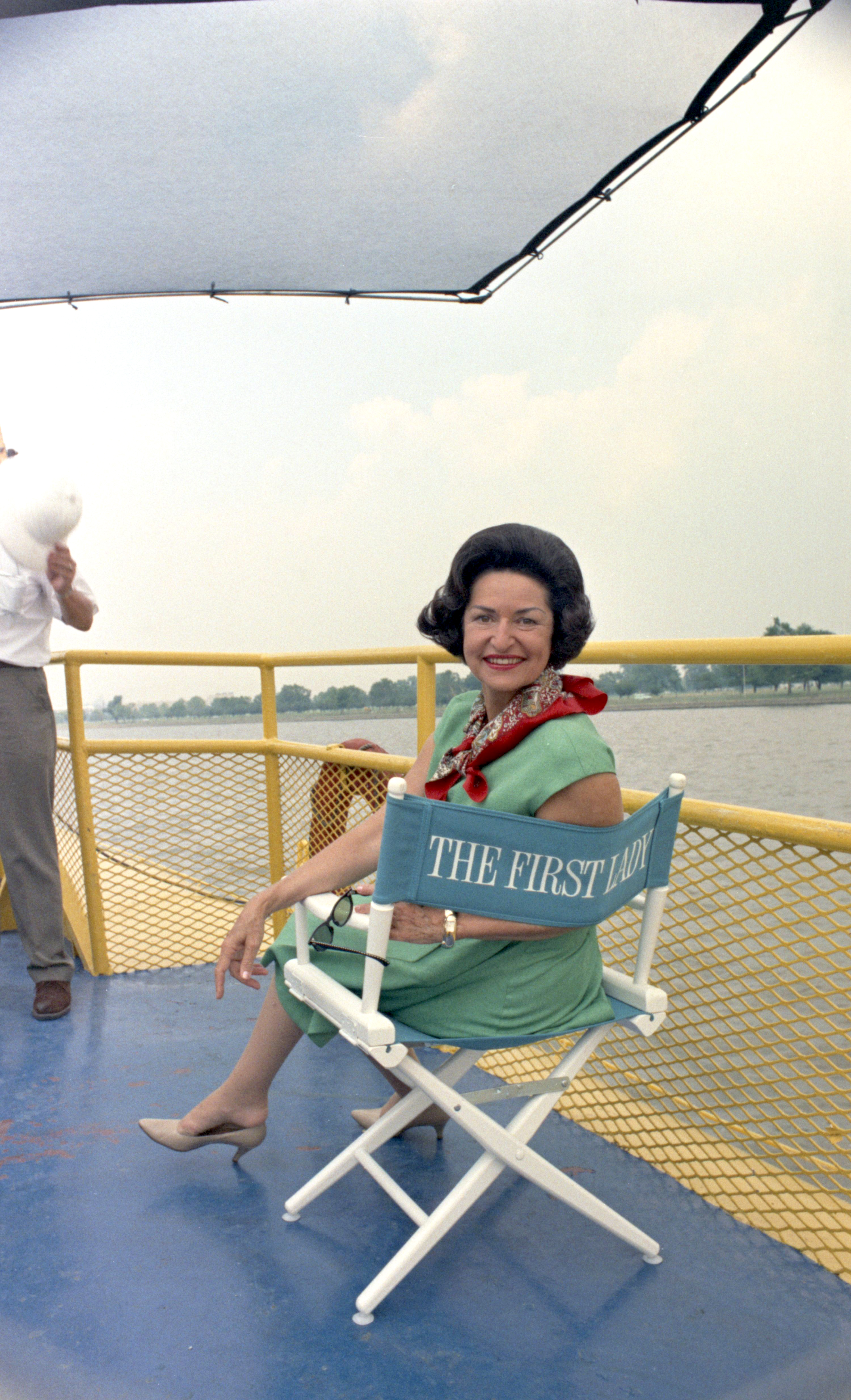 Lady Bird Johnson sits in director's chair.