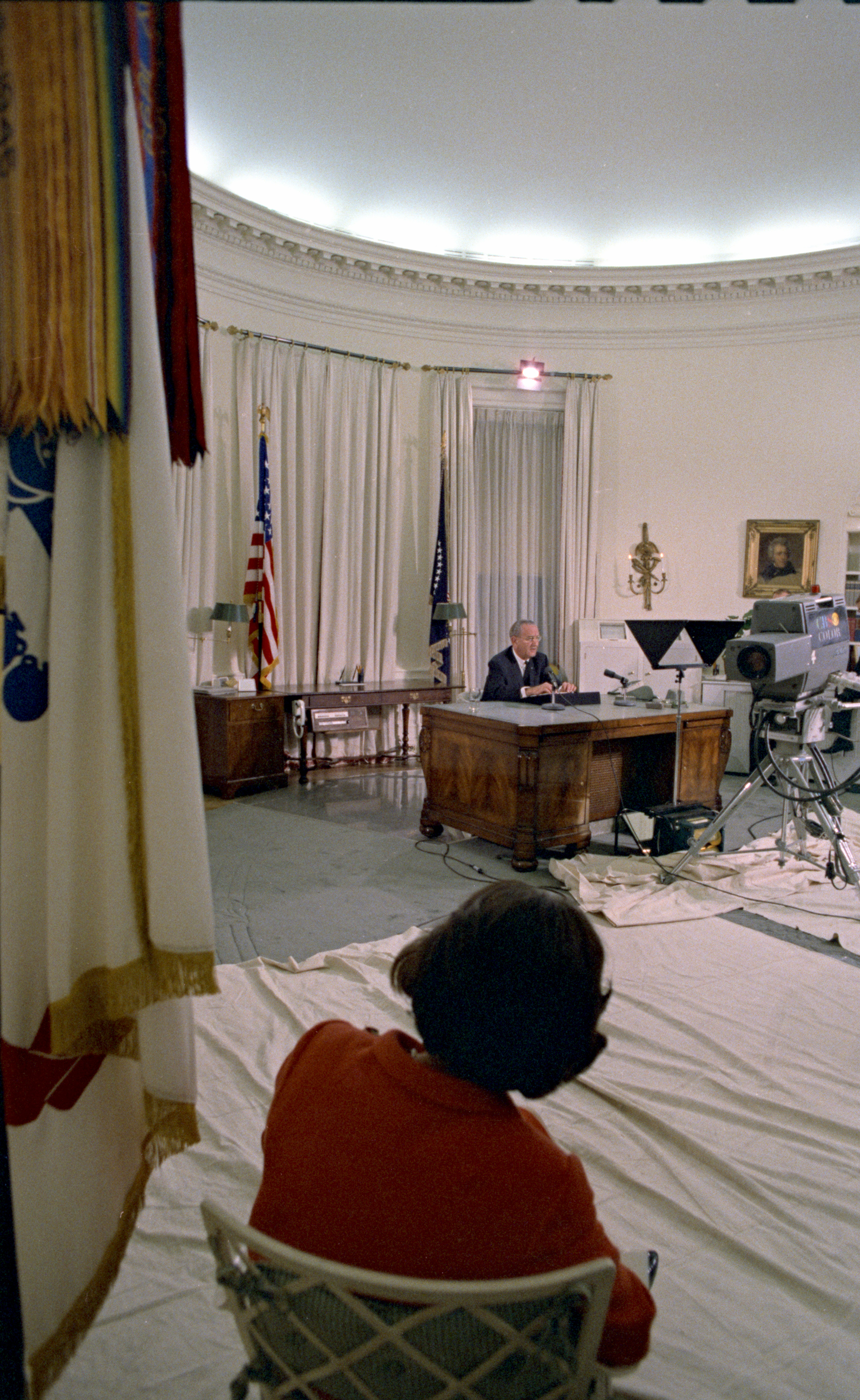 President Johnson addresses the nation as Lady Bird Johnson looks on