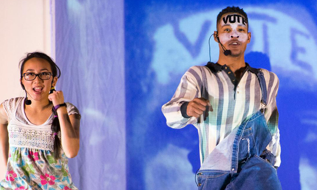 Three people dancing in front of a projected image