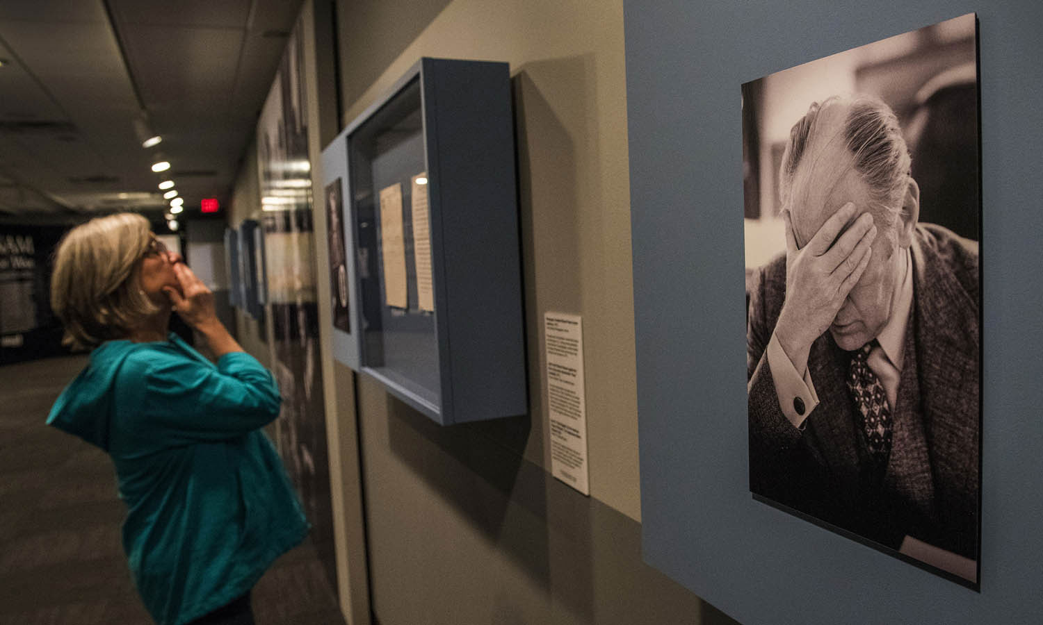 A visitor from South Carolina reads letters displayed next to a photograph of President Gerald Ford taken by White House photographer David Hume Kennerly in 1975, near the end of the Vietnam war. LBJ Library photo by Jay Godwin.
