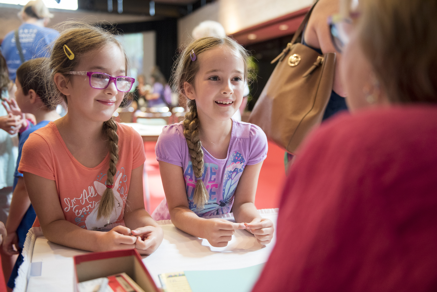 Two young girls smile at author Kathi Appelt while at a summer storytime at the LBJ Library.