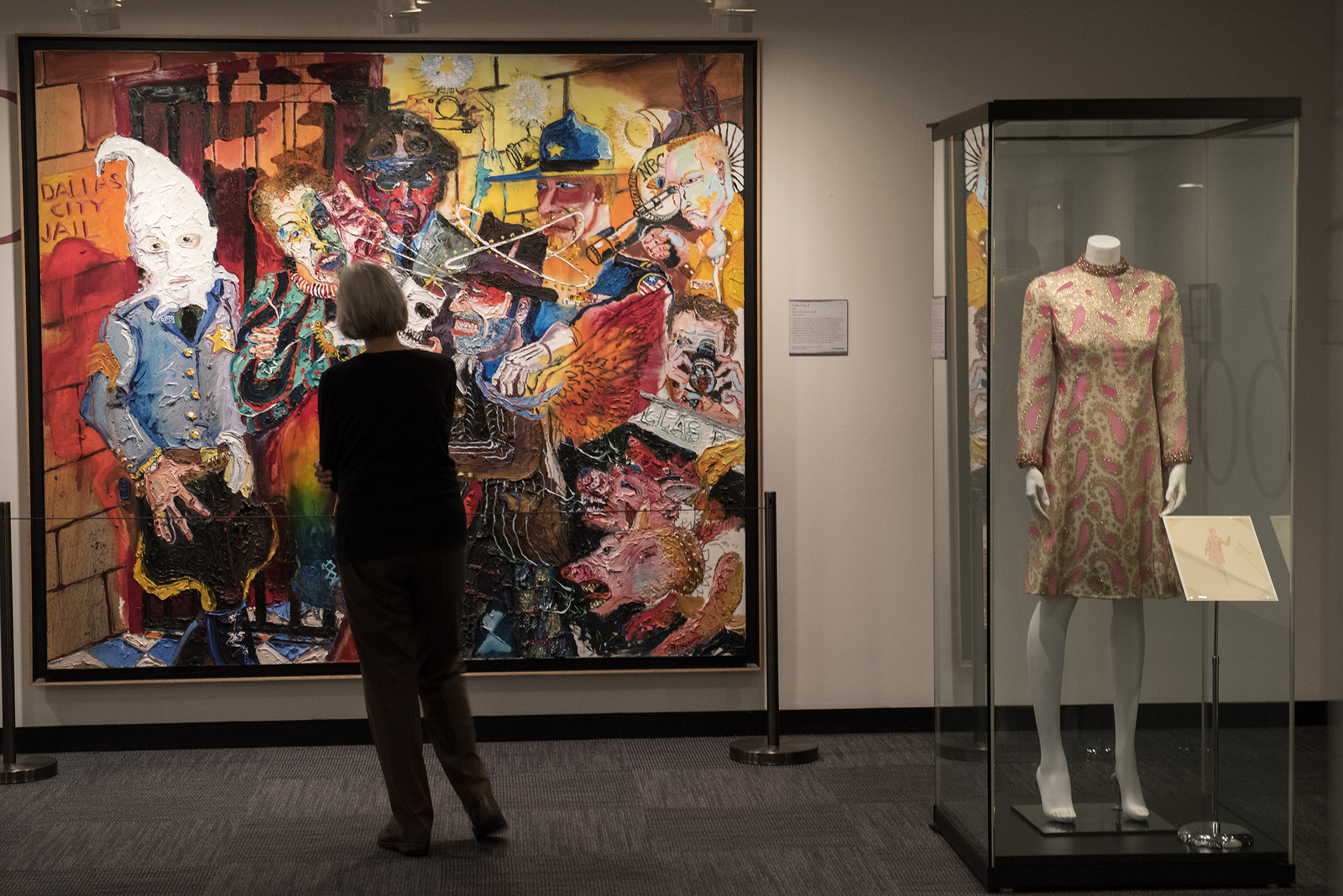 A visitor examines "Dallas Chaos II," a painting by Peter Dean, on view in the "Deep in the Vaults of Texas" exhibition at the LBJ Library.