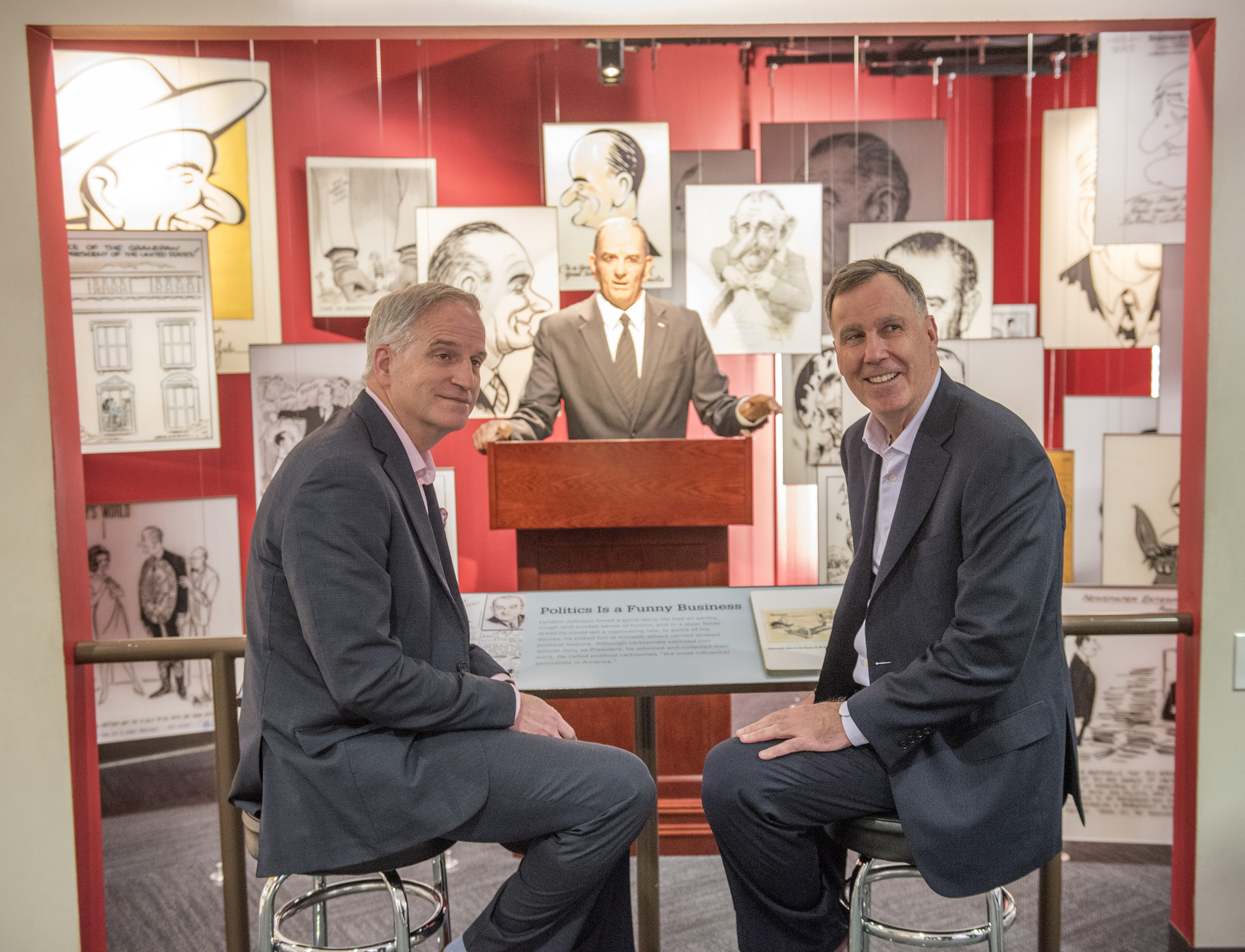 Robert Cardillo and Ed Mornston sit in front of the LBJ Animatronic exhibition at the LBJ Library.