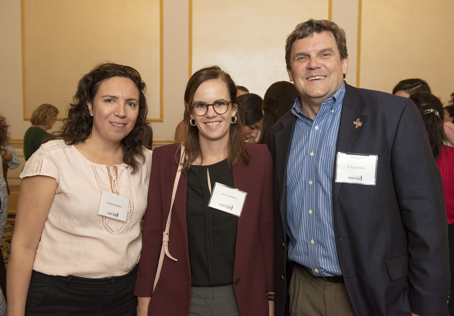 Three attendees pose together at a Future Forum reception at The Driskill Hotel.