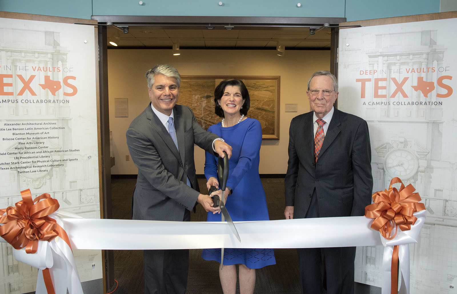 UT Austin President Gregory Fenves, (left), Luci Baines Johnson, daughter of President Lyndon Johnson, and LBJ Foundation Chairman Larry Temple cut the ribbon to open the "Deep in the Vaults of Texas" exhibition at the LBJ Library.