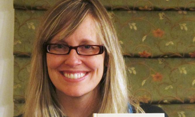Dr. Heather Marie Stur holds her book, Beyond Combat.